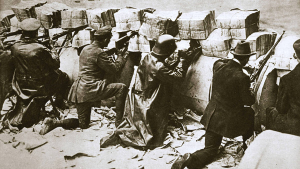 Zivilisten und Soldaten hinter einer Straßenbarrikade in Berlin, November 1918.