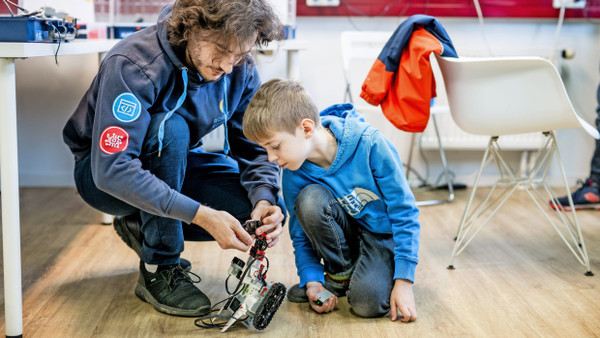 Spielerisch programmieren lernen: Trainer Maximilian Negrea (links) hilft einem Teilnehmer des Lego-Mindstorm-Kurses.