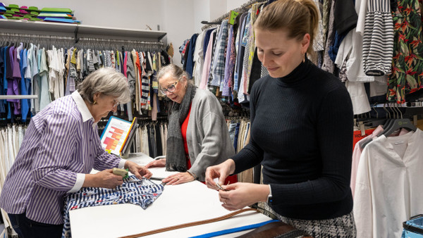 Handarbeit: Die  ehrenamtlichen Oxfam-Mitarbeiterinnen Karin Beha, Cornelia Braumann und Nadine Hermann sortieren gespendete Kleidung.