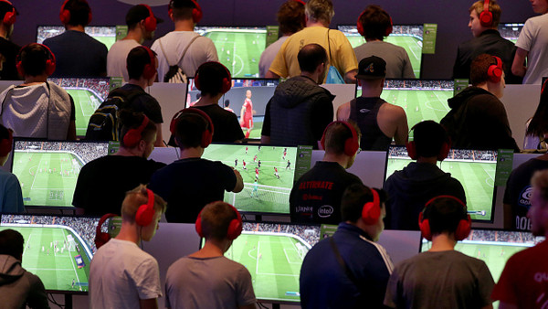 Besucher der Kölner Computerspielmesse Gamescom spielen das Computerspiel „FIFA 18“. Das hatte im Gegensatz zum neuen Spiel noch keine Altersbeschränkung.