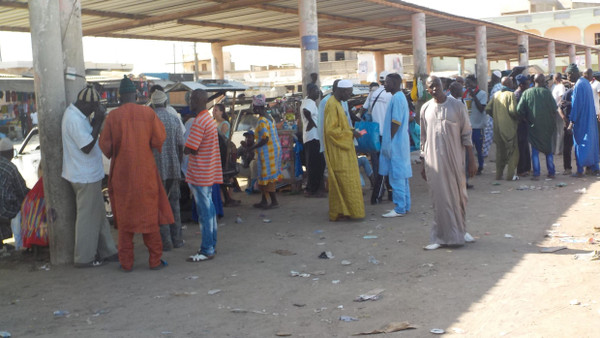 Einwohner von Saint-Louis, die in anderen Städten des Senegal eine Gelegenheitsarbeit annehmen wollen, sammeln sich an dieser Bushaltestelle.