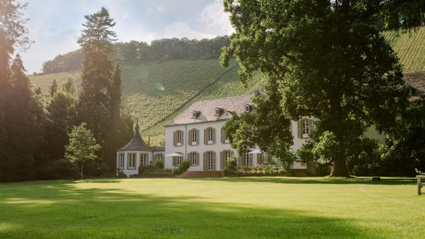 Idyll an der Saar: das Othegraven-Gutshaus, eingefasst vom Park und den Steillagen des berühmten Altenbergs.