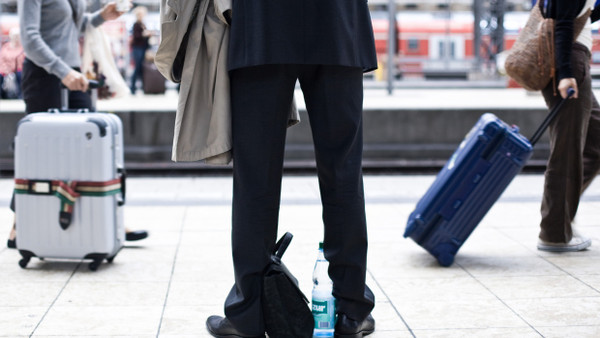 Ein Geschäftsreisender wartet am Bahnsteig des Frankfurter Hauptbahnhofs auf seinen Zug.
