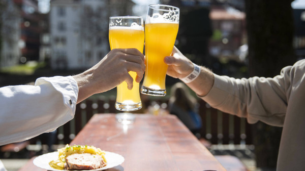 In Tübingen stoßen Besucher eines wieder geöffneten Biergartens an.