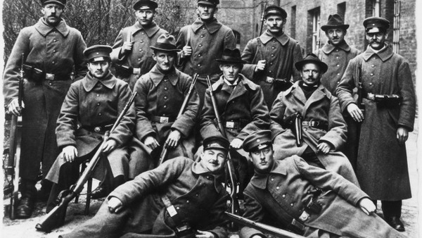 Eine Gruppe bewaffneter Arbeiter und Soldaten in Kiel im November 1918 für einen Fotografen.
