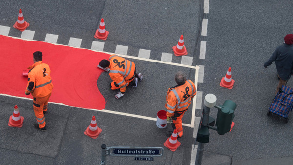 Mit roter Farbe markieren Arbeiter eine Fahrradspur auf der Gutleutstraße in der Frankfurter Innenstadt.