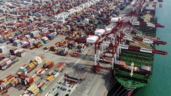 Ein Containerschiff im Hafen von Qingdao in der ostchinesischen Provinz Shandong wartet darauf, beladen zu werden.