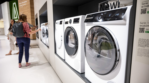 Besucher betrachten auf der Elektronikmesse IFA Waschmaschinen von Bosch.