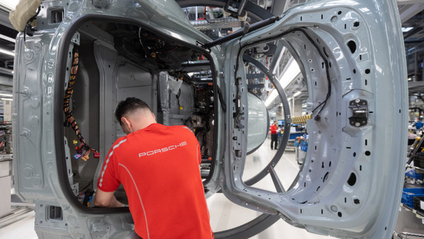 Der Trend dreht sich. Ein Mitarbeiter der Porsche AG montiert im Stammwerk in Zuffenhausen einen vollelektrischen Porsche Taycan.