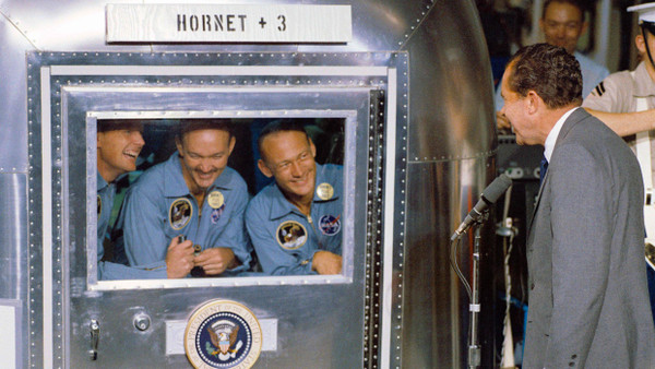 Zurück auf der Erde: Neil Armstrong, Michael Collins und Edwin Aldrin im Bergungsschiff U.S.S. Hornet im Gespräch mit Präsident Nixon (von links nach rechts)