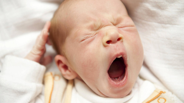 Anstecken kann es schon, auch wenn es selbst noch immun ist: gähnendes Baby