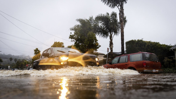 Autos fahren durch die überfluteten Straßen von Santa Barbara.