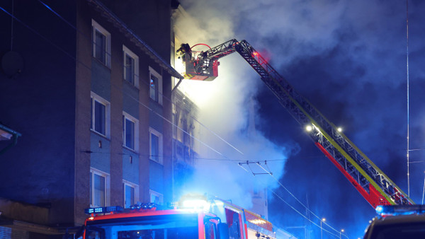 Solingen: Von einer Drehleiter aus bekämpft ein Feuerwehrmann den Brand in einem Mehrfamilienhaus.