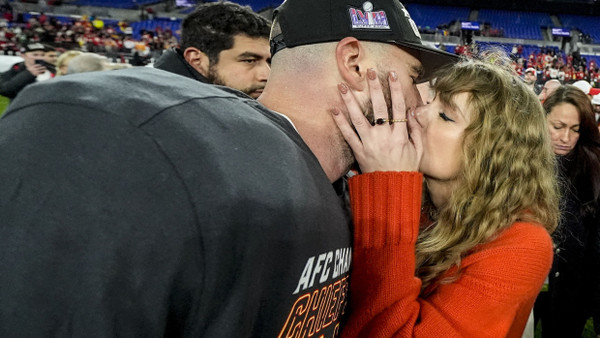 Die Musikerin Taylor Swift küsst Kansas City Chiefs Tight End Travis Kelce nach dem NFL-Footballspiel auf dem Spielfeld.