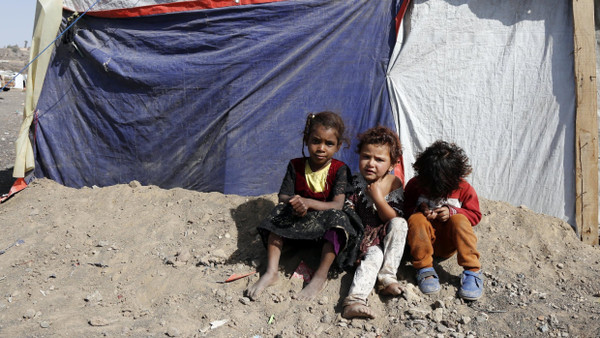 Kinder sitzen auf dieser Aufnahme von 2022 vor einem Zelt in einem Lager für Binnenflüchtlinge in der Nähe von Sanaa in Jemen.
