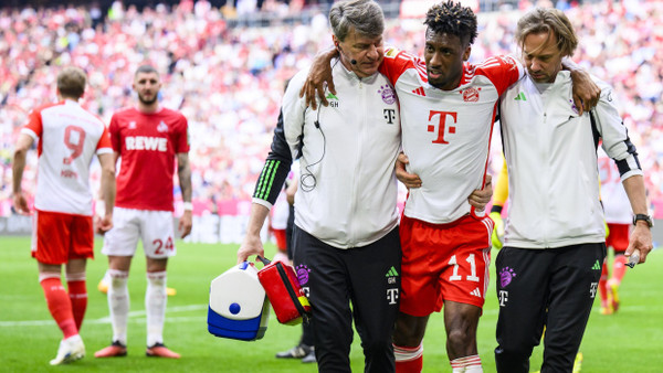 Der verletzte Kingsley Coman vom FC Bayern wird vom Platz begleitet.