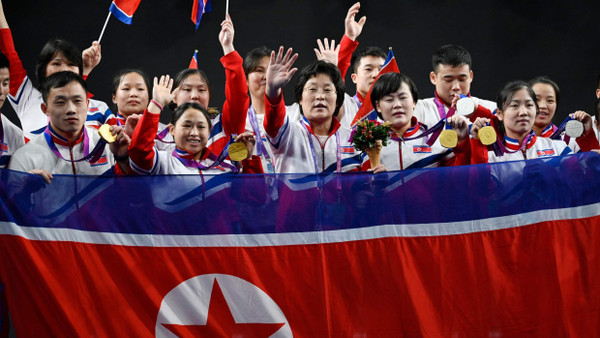 Nordkoreas Gewichtheberteam jubelt in Hangzhou: Bei der Siegerehrung wurde die Flagge des Landes verbotenerweise gehisst.