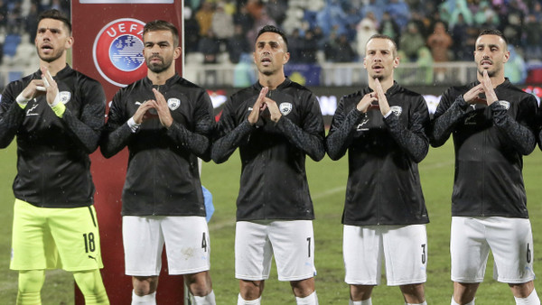 Israels Nationalspieler vor der Partie in Pristina: sie formen mit den Händen ein halbes, gebrochenes Herz
