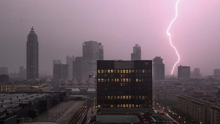 Gewitter über Frankfurt: Zwischen den Hochhäusern der Skyline schlägt ein Blitz ein.