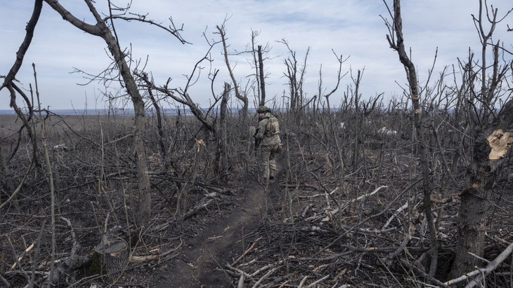 Verbrannte Erde, abgeknickte Bäume: Ein ukrainischer Soldat läuft im März 2024 zu seiner Stellung im Gebiet Donezk