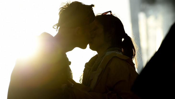 Ein junges Pärchen küsst sich beim Hurricane-Rockfestival im Sonnenuntergang.
