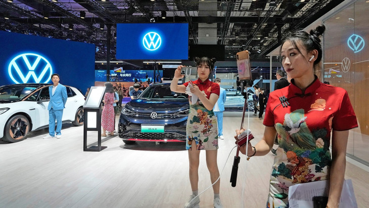 Schlaglicht auf China: Videobloggerinnen vor einem VW-Modell auf der Automesse in Schanghai 2023