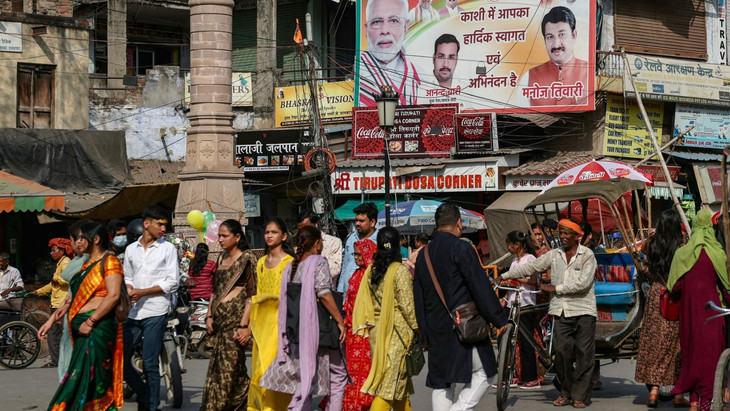Populismus auf Indisch: Fußgänger vor einem Wahlplakat von Modis Bharatiya Janata Party in Varanasi am 16. März 2024