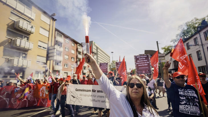 Eine Teilnehmerin brennt auf dem Demonstrationszug durch die Frankfurter Innenstadt Pyrotechnik ab.