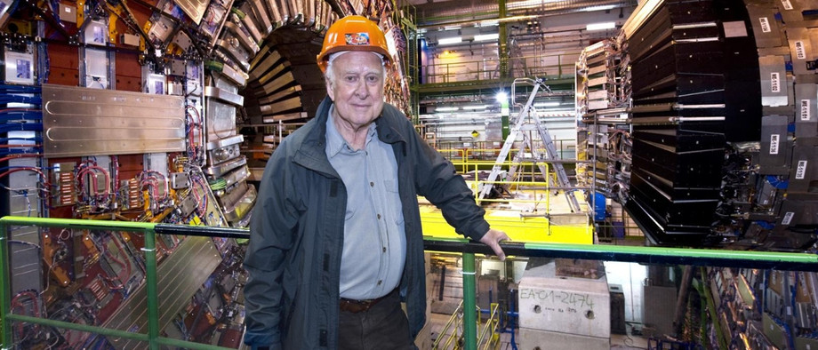 Peter Higgs bei einem Besuch am Forschungszentrum CERN. Im Hintergrund der CMS-Teilchendetektor, mit dem 2012 die Existenz des Higgs-Bosons nachgewiesen werden konnte.