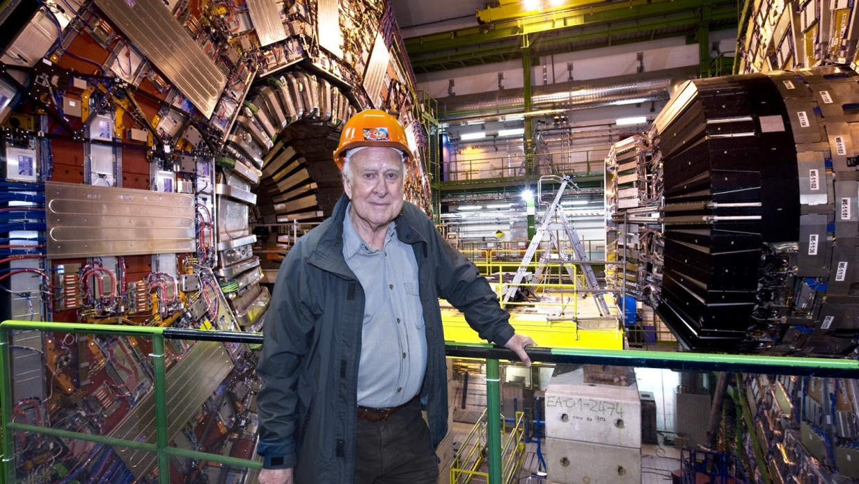 Peter Higgs bei einem Besuch am Forschungszentrum CERN. Im Hintergrund der CMS-Teilchendetektor, mit dem 2012 die Existenz des Higgs-Bosons nachgewiesen werden konnte.