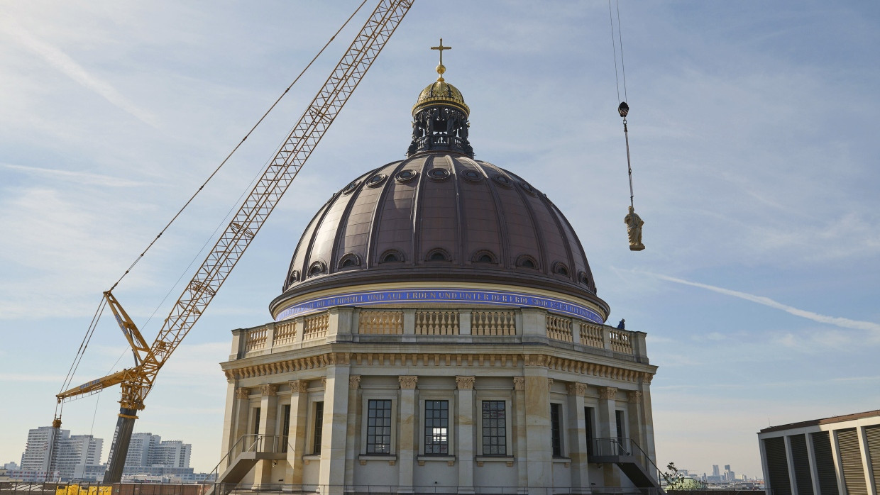 Die Skulptur eines Propheten (hier ist es Jeremias) wird auf die Balustrade der Kuppel des Berliner Schlosses gehoben