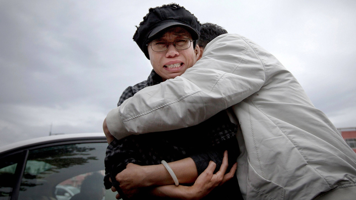 Liu Xia, die Witwe des Friedensnobelpreisträgers Liu Xiabobo, wird im Juni 2013 von einem Angehörigen vor dem Gefängnis in Huairo, in dem der Bruder der Witwe inhaftiert ist, getröstet.