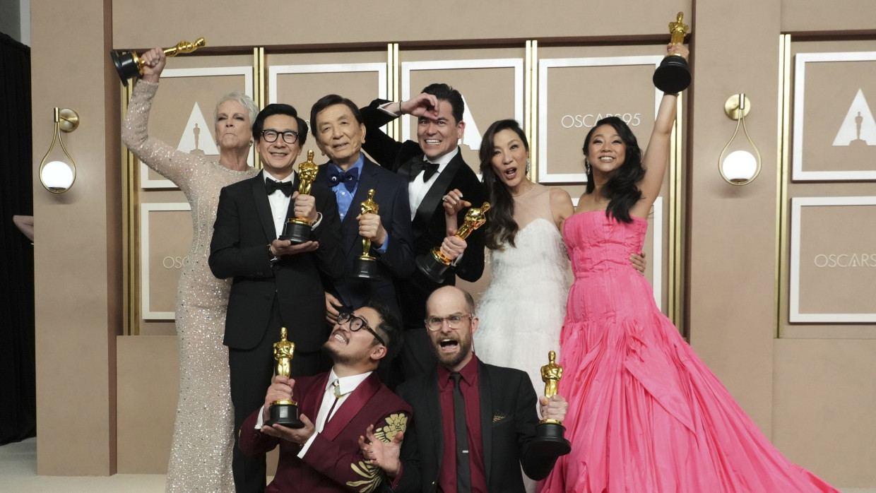 „Everything Everywhere All at Once“ gewann sieben Oscars: Jamie Lee Curtis (von links oben), Ke Huy Quan, James Hong, Jonathan Wang, Michelle Yeoh und Stephanie Hsu sowie davor die beiden Regisseure Daniel Kwan (links) und Daniel Scheinert