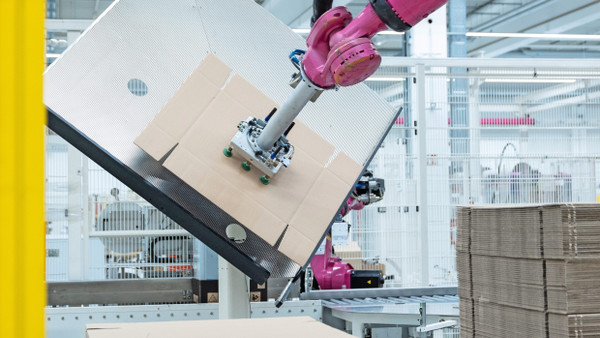 Kuka robots shape large cardboard boxes at the packing station in seconds.