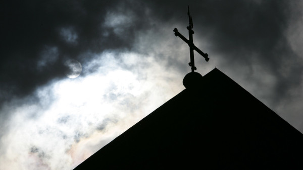 Dunkle Wolken über einer katholischen Kirche (Symbolbild)