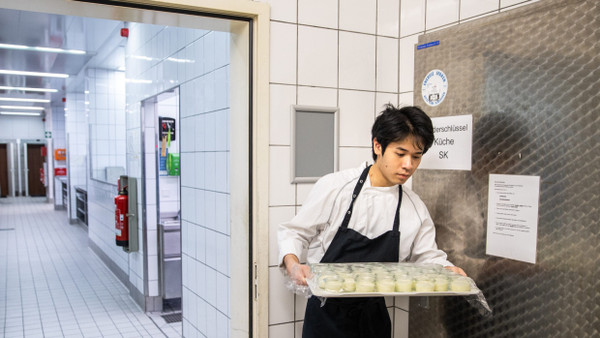 Hai Duong Hoang bringt in der Küche vom Best Western Premier IB Hotel Friedberger Warte Lebensmittel in die Kühlkammer.