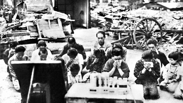 15. August 1945: Eine Gruppe von Japanern hört die Rundfunkansprache des Kaisers, in der er die Kapitulation Japans erklärt. Der Ort der Aufnahme ist nicht bekannt.
