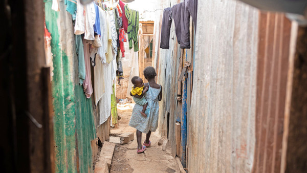 Kinder einer Tuberkulosepatientin spazieren durch den Mathare-Slum. Die ältere Schwester sorgt für ihr Geschwisterchen.