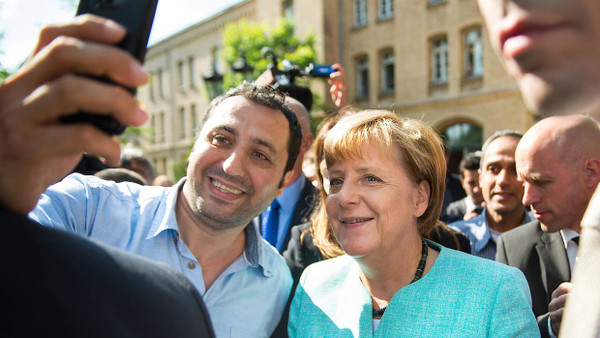 Ein täuschendes Bild: Dass von den berühmten Selfies von Flüchtlingen mit der Bundeskanzlerin eine zusätzliche Anziehungswirkung auf Migranten ausgegangen sei, ziehen Kieler Wissenschaftler in Zweifel.