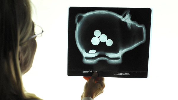 Keine schwäbische Hausfrau, sondern eine Münchner Radiologin schaut einem Sparschwein in den Bauch.