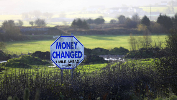 Straßenschild in einer Hecke an der Grenze zwischen Nordirland und der Republik Irland