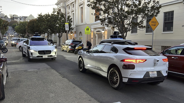 Trifft hier die Zukunft aufeinander? Zwei fahrerlose Taxis begegnen sich im März 2023 in San Francisco, Kalifornien
