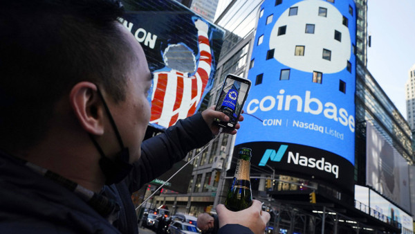 Ein guter Grund zum Feiern für diesen Mitarbeiter: Coinbase-Schriftzug am Times Square in New York zum Börsendebüt