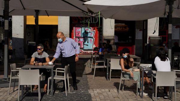Ein Kellner bedient einen Mann im Außenbereich des Restaurants in Madrid.
