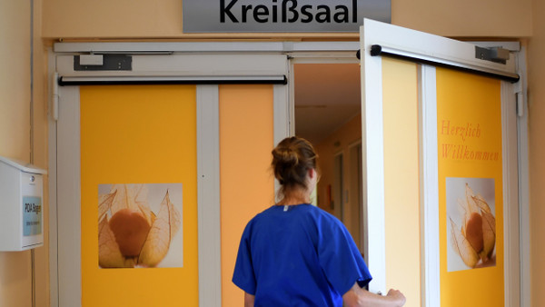 Mitarbeiterin einer Klinik vor dem Kreißsaal: In Deutschland kommen immer mehr Kinder per Kaiserschnitt zur Welt (Symbolbild).