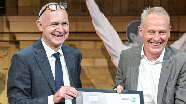 Christian Streich (Mitte), Fußballtrainer des SC Freiburg, erhält den Ehrenpreis von DFB-Präsident Bernd Neuendorf (links).
