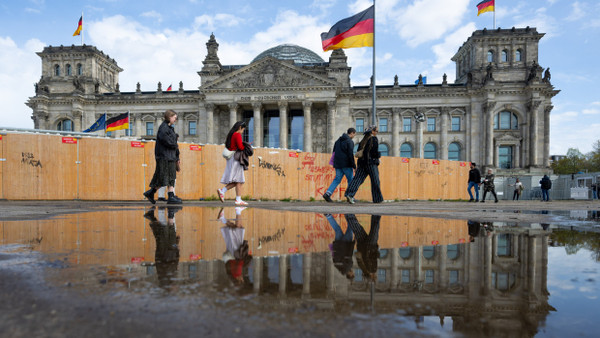 Passanten gehen am Reichstagsgebäude vorbei.