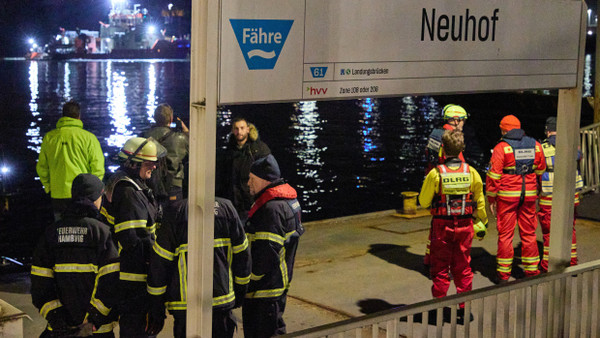 Feuerwehrleute stehen am Anleger Neuhof. In der Hamburger Elbe haben Taucher in der Nähe der Köhlbrandbrücke nach einem vermissten Menschen gesucht.