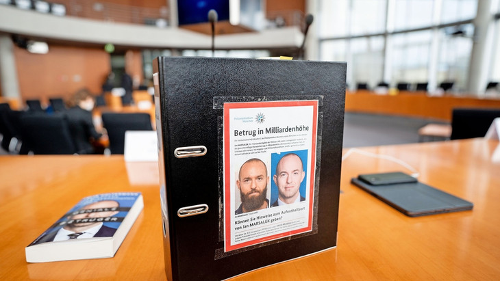 Auf der Flucht: Marsaleks Fahndungsbild 2022 auf einem Ordner im Wirecard-Untersuchungsausschuss des Bundestages