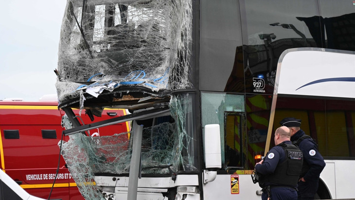 Französische Polizeibeamte stehen neben einem beschädigten Bus nach einem Unfall zweier Busse mit französischen und deutschen Schülern.